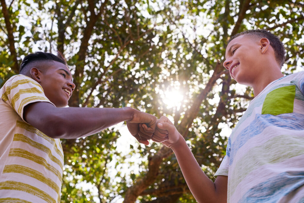 Two youth fist bumping.