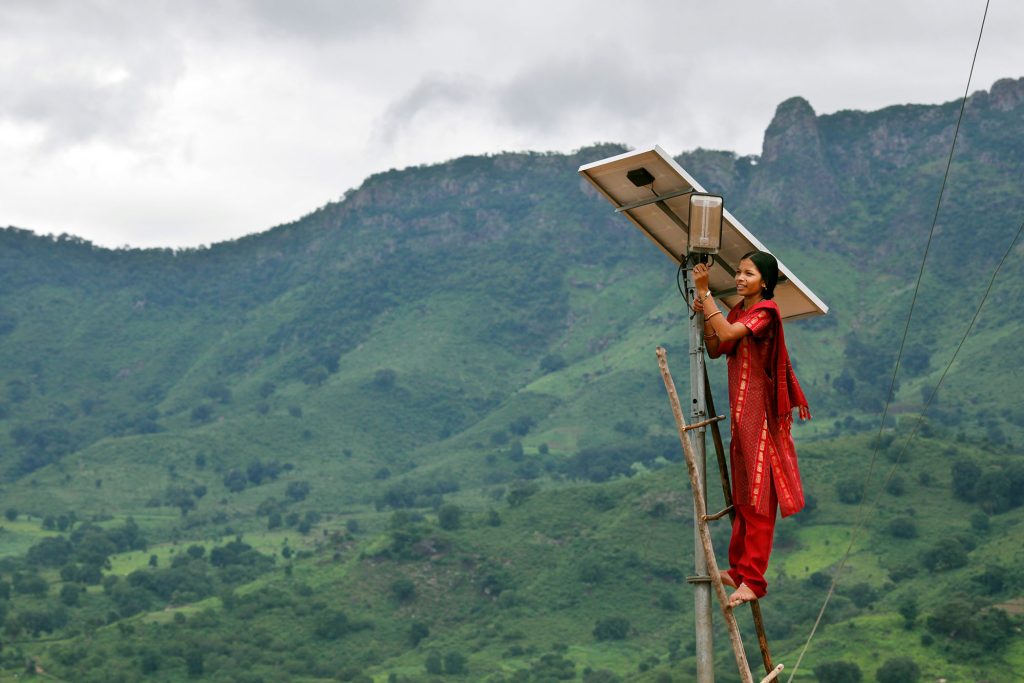Women holding solar panel in Asia.